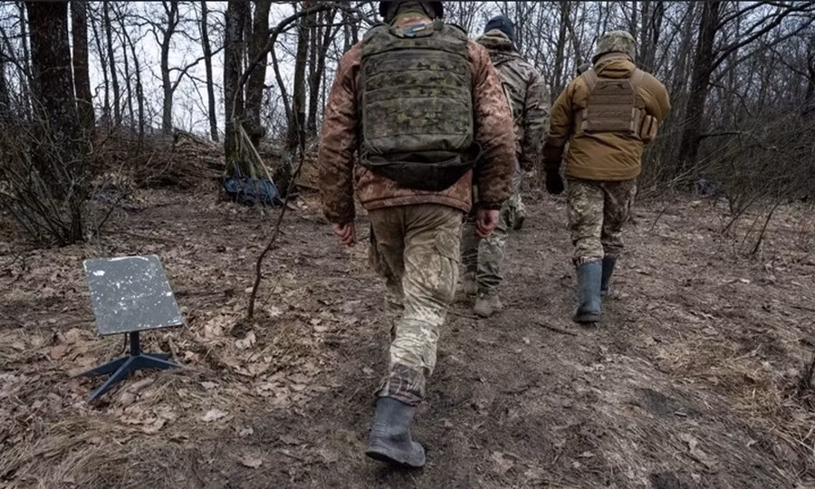 Binh sĩ Ukraine đi qua một thiết bị đầu cuối internet vệ tinh Starlink.