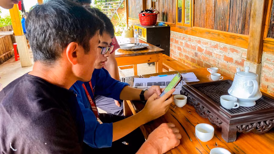 Sinh viên Khoa Khoa học và Công nghệ Giáo dục, Đại học Bách khoa Hà Nội hướng dẫn người dân ứng dụng công nghệ vào quản lý homestay và quảng bá văn hoá, du lịch địa phương.