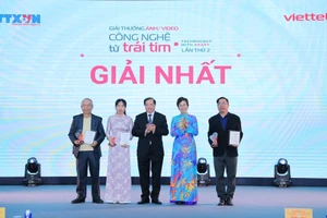 Tổng Giám đốc TTXVN Vũ Việt Trang, Chủ tịch Hội đồng Giải thưởng và Thứ trưởng Bộ Văn hóa, Thể thao và Du lịch Tạ Quang Đông trao giải Nhất cho các tác giả. (Ảnh: Lê Đông - TTXVN)