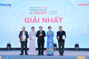 Tổng Giám đốc TTXVN Vũ Việt Trang, Chủ tịch Hội đồng Giải thưởng và Thứ trưởng Bộ Văn hóa, Thể thao và Du lịch Tạ Quang Đông trao giải Nhất cho các tác giả. (Ảnh: Lê Đông - TTXVN)