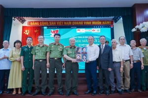Anh hùng LLVTND Phan Văn Lai trao tượng trưng 4 di ảnh nữ Anh hùng Liệt sĩ đầu tiên của Lực lượng CAND cho Bảo tàng Phụ nữ Việt Nam. (Ảnh: BTC).