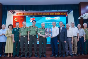 Anh hùng LLVTND Phan Văn Lai trao tượng trưng 4 di ảnh nữ Anh hùng Liệt sĩ đầu tiên của Lực lượng CAND cho Bảo tàng Phụ nữ Việt Nam. (Ảnh: BTC).