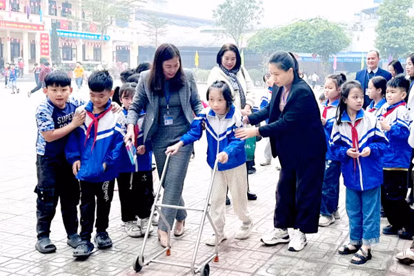 Em Kim Thanh Bình (lớp 3B, Trường Tiểu học Sơn Cẩm 1, phường Quan Triều, tỉnh Thái Nguyên) được hỗ trợ tập đi. 