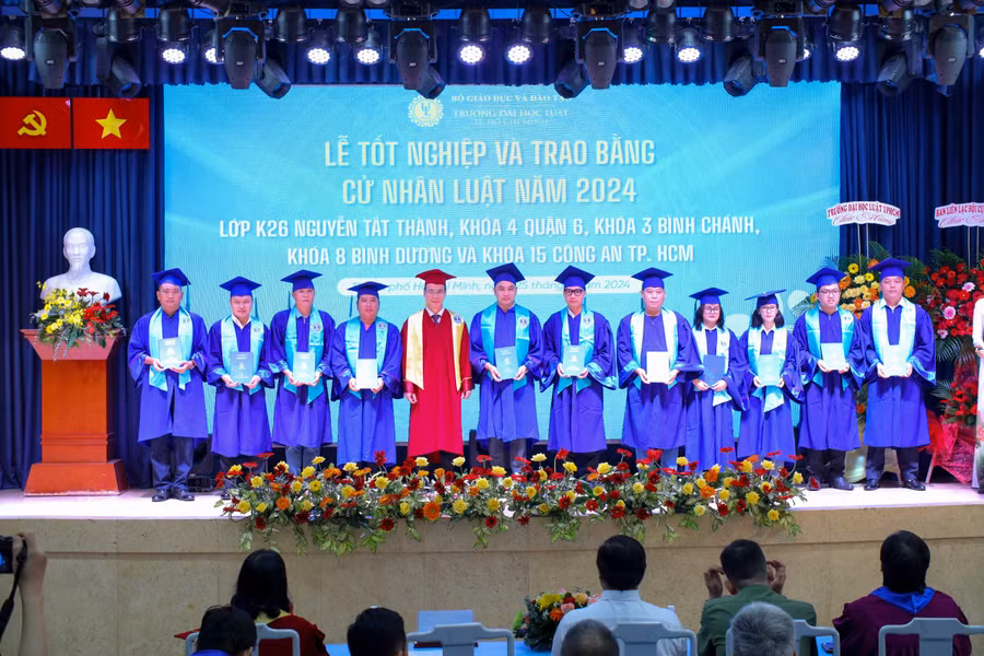 PGS.TS Vũ Văn Nhiêm trao bằng và chụp hình lưu niệm cùng các tân cử nhân. Ảnh: NTCC