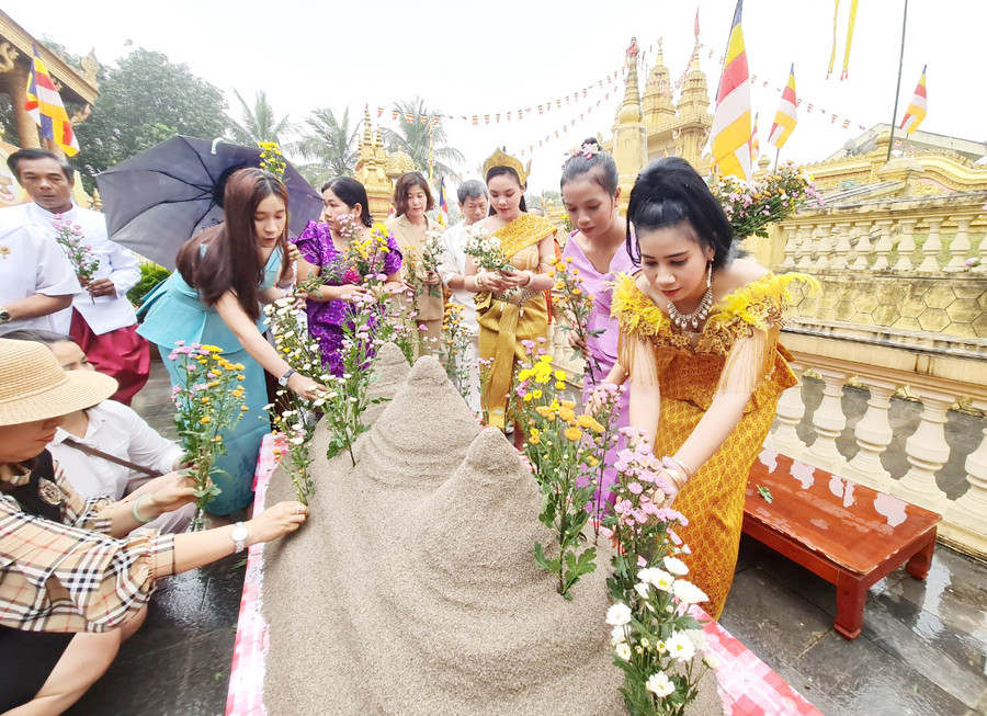 Buổi chiều là lễ đắp núi cát, gọi là Puôn-phnum-khsach.Tục đắp núi cát thể hiện lòng tôn kính đến Đức Phật, Đức Bồ Tát, có ý nghĩa ngăn trở ma quỷ và những điều xấu, đồng thời nhắc nhở mọi người nên tích phúc, đức để ngày một cao vời vời, lớn lao như núi và lan tỏa dần khắp bốn phương, tám hướng.