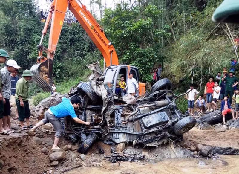 Lực lượng chức năng đang đưa xác xe ô tô bị vùi sâu dưới lòng suối lên bờ.