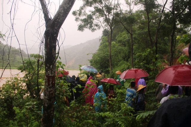 Nhiều người dân đứng trên bờ sông theo dõi anh Huy thoát thân.