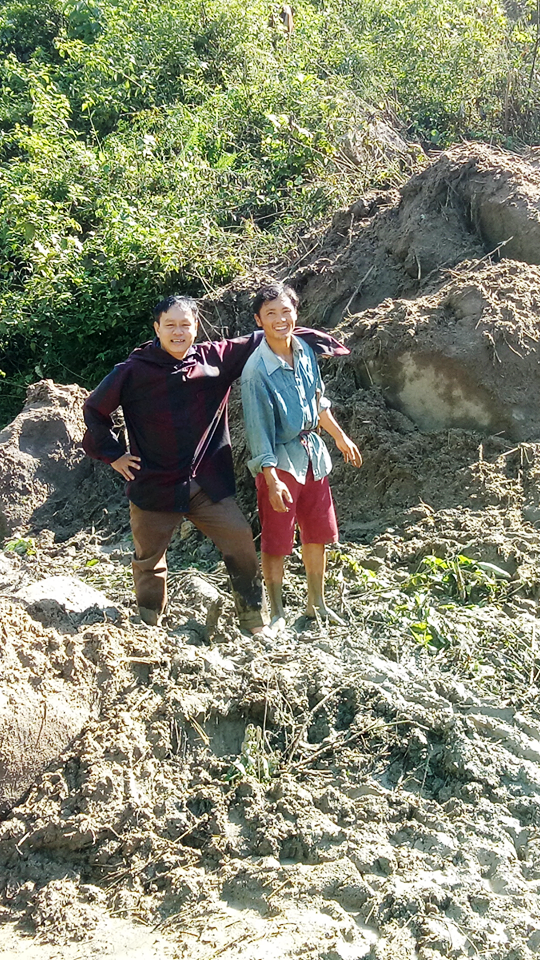 Bí thư Chi bộ bản Suối Ún, xã Mường Lý xuống giúp đỡ thầy giáo Lang Văn Long (trái) khiêng xe vượt qua cung đường.