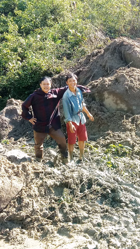 Bí thư Chi bộ bản Suối Ún, xã Mường Lý xuống giúp đỡ thầy giáo Lang Văn Long (trái) khiêng xe vượt qua cung đường.