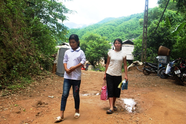 Em Nguyễn Thị Dược (học sinh lớp 5, Trường Tiểu học Na Mèo), nhà ở bản Sa Ná cùng người thân đi nhận hàng cứu trợ.