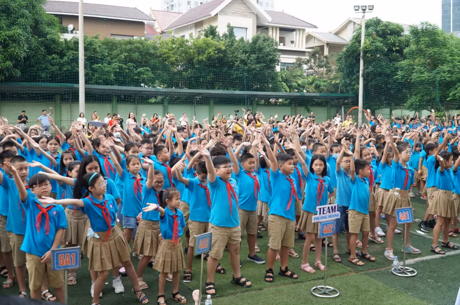 Màn đồng diễn chào mừng năm học mới với sự tham gia hứng khởi của cả học sinh lẫn phụ huynh phía sau.