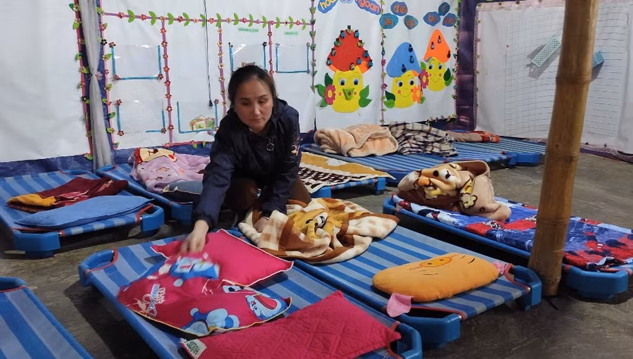 Cô giáo chuẩn bị chỗ ngủ cho các bé. Ảnh: Thế Lượng.