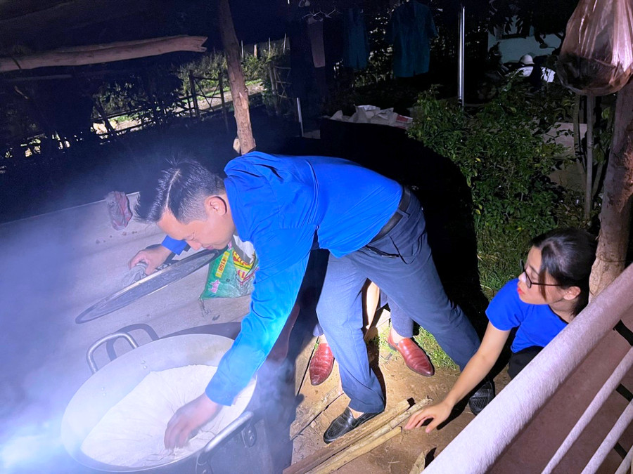 Anh Lâu Văn Phía – Bí thư Huyện đoàn Mường Lát kiểm tra nồi xôi. Ảnh: Thế Lượng.