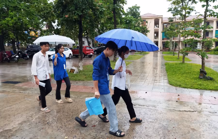 Thanh niên tình nguyện che mưa cho thí sinh ở điểm thi tại kỳ thi vào lớp 10 vừa qua. Ảnh: Tỉnh đoàn Thanh Hóa.
