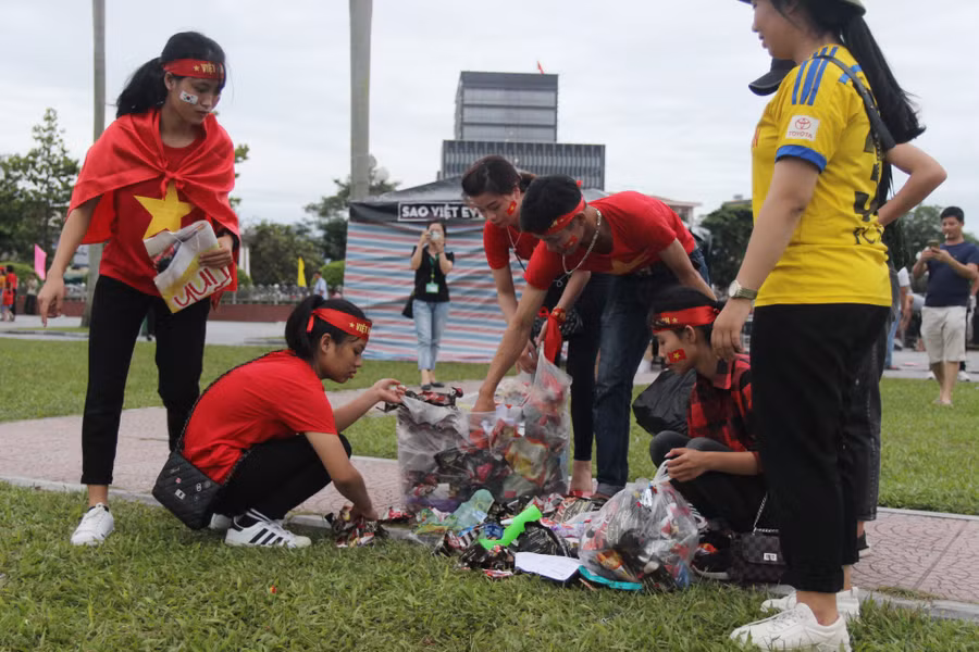 Nhiều bạn trẻ nán lại nhặt rác tại Quảng trường Hồ Chí Minh sau khi trận bóng kết thúc