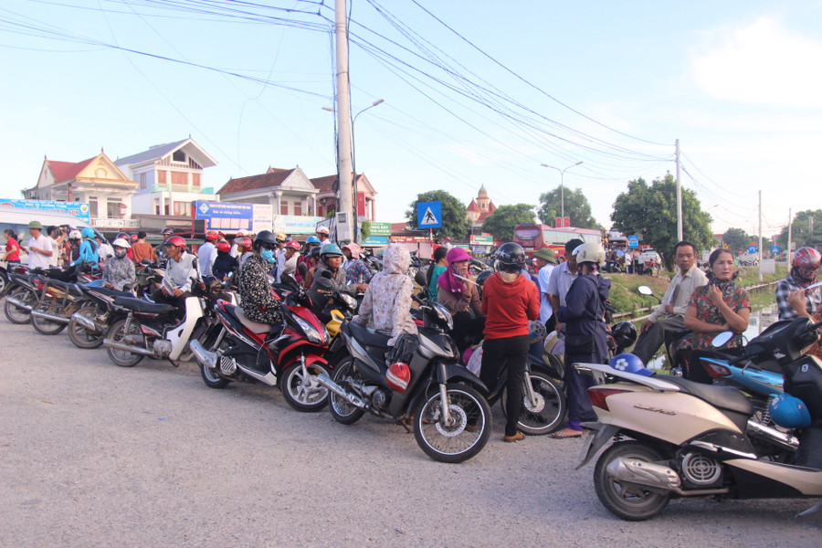 Phụ huynh dựng xe ở bên lề đường đứng đợi con.