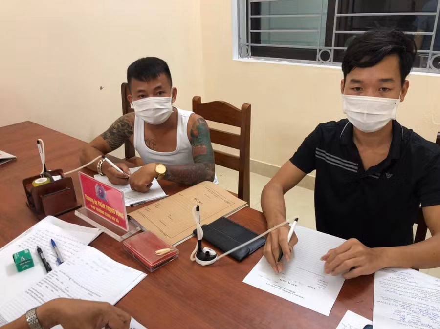 Cơ quan chức năng tiến hành lập biên bản với tài xế P. (bên phải ảnh) và T. Ảnh: Công an Tuyên Quang