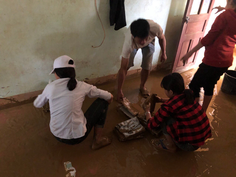 Các em học sinh nhặt lại sách vở bị ngâm trong nước lũ