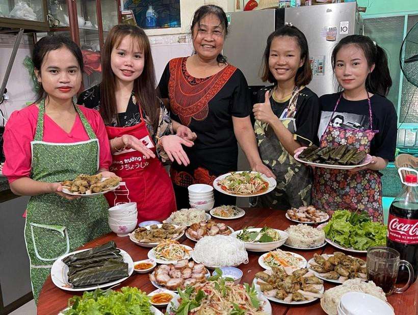 Các bạn sinh viên Lào được “mẹ đỡ đầu” Trần Thị Nguyện dẫn về nhà dạy nấu món ăn Việt Nam. Các bạn sinh viên Lào được “mẹ đỡ đầu” Trần Thị Nguyện dẫn về nhà dạy nấu món ăn Việt Nam.