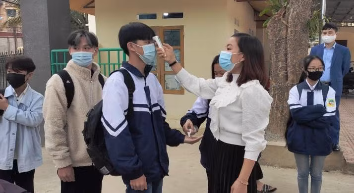 Giáo viên đo thân nhiệt cho học sinh ở Trường THPT Quan Hóa (Thanh Hóa)