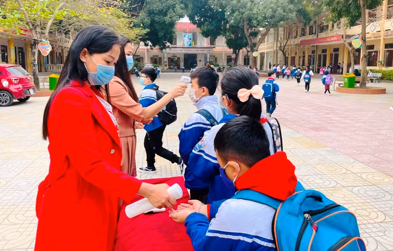 Giáo viên trường Tiểu học Đông Vệ 1, TP Thanh Hóa thực hiện đo thân nhiệt và xịt nước sát khuẩn cho học sinh trước khi vào lớp.