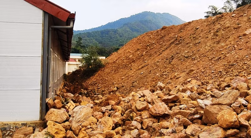 Đá từ trên vách ta luy đã sạt xuống sát dãy nhà bán trú của học sinh.