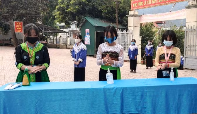 Sau khi đo thân nhiệt, học sinh tự sát khuẩn tay.