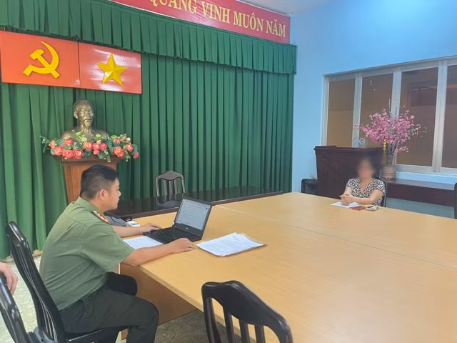 Cán bộ công an làm việc với bà T.H.L. Ảnh: Công an TPHCM