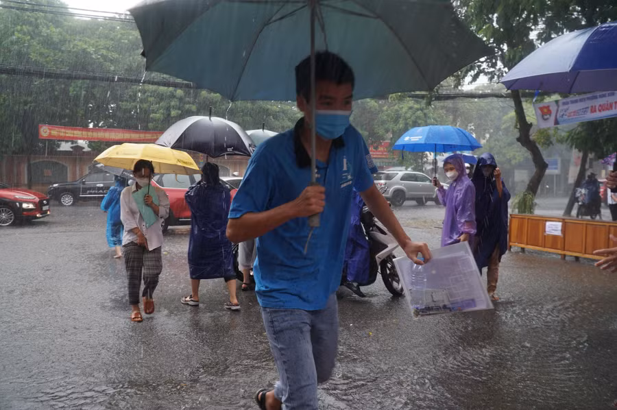 Chiều 7/7, thí sinh làm bài trắc nghiệm đầu tiên thi tốt nghiệp THPT năm 2022. Thí sinh hối hả bước vào điểm thi trong thời tiết mưa lớn.