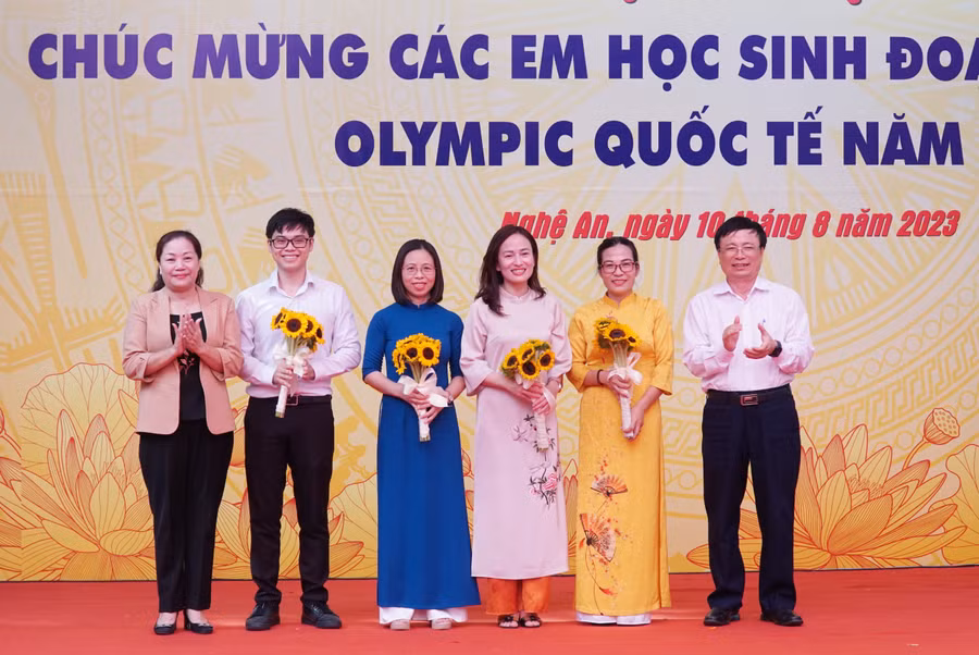 Bà Nguyễn Thị Thu Hường - Trưởng ban Tuyên giáo Tỉnh ủy Nghệ An và ông Bùi Đình Long - Phó Chủ tịch UBND tỉnh khen thưởng giáo viên bồi dưỡng học sinh đoạt huy chương Olympic quốc tế. Ảnh: Hồ Lài.