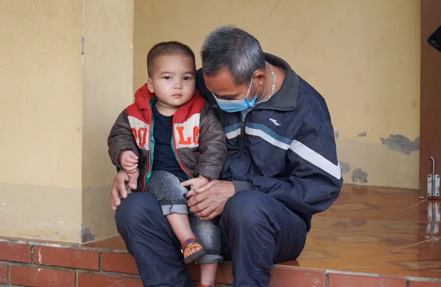 Hai ông cháu đến chờ nhận quà tết. Trên địa bàn, có nhiều học sinh có bố mẹ làm ăn xa, để lại con cái cho ông bà chăm sóc, nuôi dưỡng.