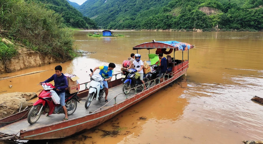 Đưa sách giáo khoa vượt sông Mã. Ảnh: Thế Lượng.