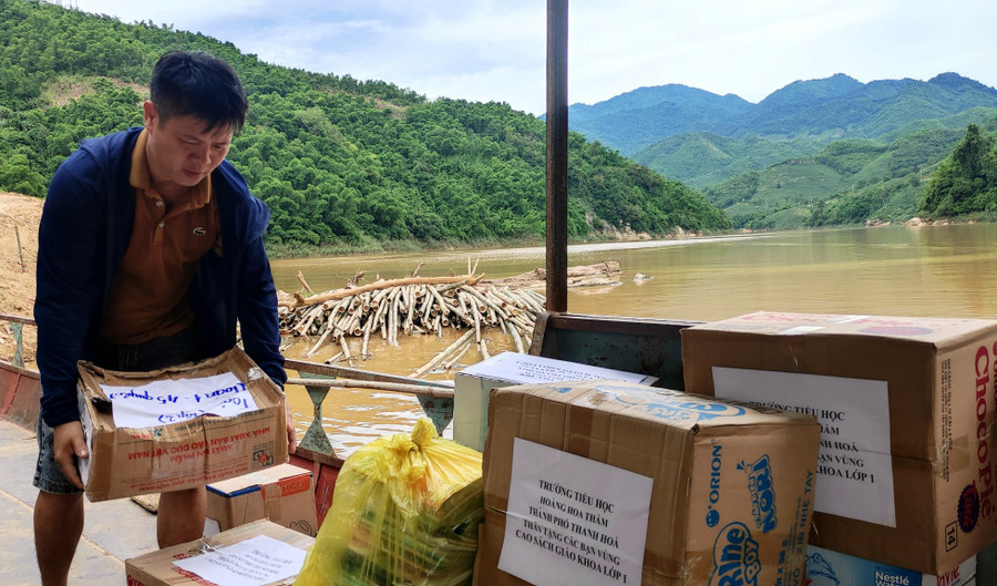 Bốc xếp sách lên đò để vượt sông Mã. Ảnh: Thế Lượng. Bốc xếp sách lên đò để vượt sông Mã. Ảnh: Thế Lượng.