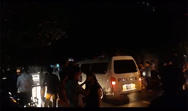 Lê Ngọc Sơn được đưa lên xe cảnh sát về trụ sở CQĐT