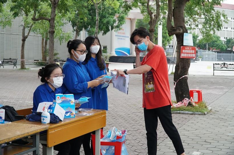 Đoàn thanh niên tình nguyện thay khẩu trang cho thí sinh trước khi vào phòng thi tại điểm thi Trường THPT chuyên Đại học Vinh.