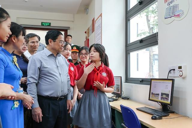 Các em học sinh giới thiệu hoạt động học tập tại trường với Thủ tướng. Ảnh: VGP/Nhật Bắc