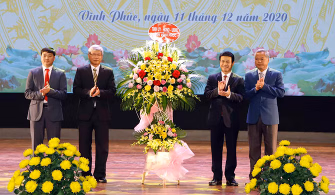 Phó Chủ tịch UBND tỉnh Vĩnh Phúc Vũ Chí Giang (thứ 2 từ phải qua) tặng hoa chúc mừng Ban Dân tộc