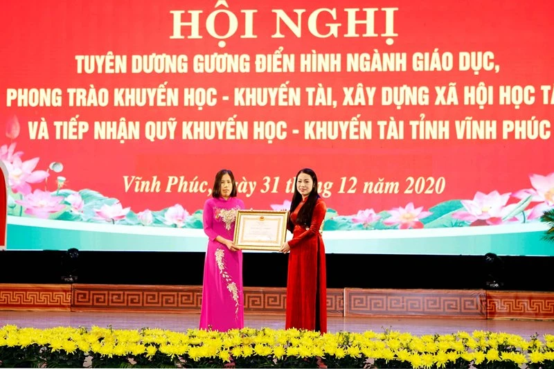 Thừa ủy quyền của Chủ tịch nước, Bí thư Tỉnh ủy Vĩnh Phúc Hoàng Thị Thúy Lan (bìa phải) trao Huân chương Lao động hạng Ba cho nguyên Hiệu trưởng Trường THPT Nguyễn Viết Xuân.