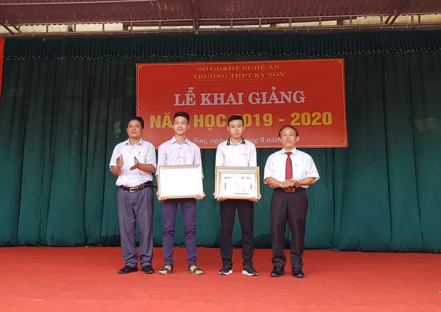 Ban giám hiệu Trường THPT Kỳ Sơn trao giấy khen của GĐ Sở GD&ĐT cho 2 học sinh Lương Thế Mạnh và Lương Văn Đức.