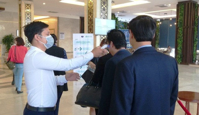 Thực hiện kiểm tra thân nhiệt các đại biểu dự hội thảo.