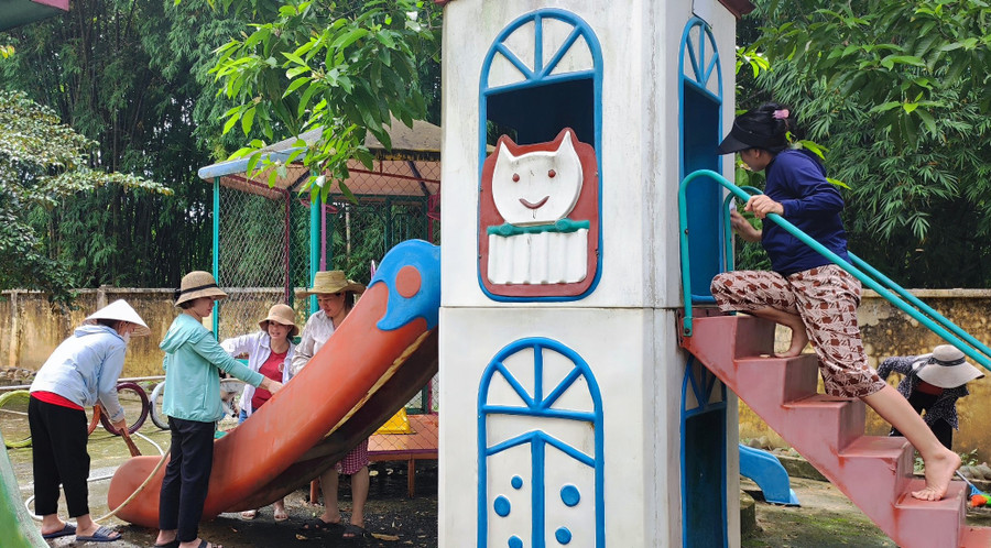 Các cô giáo làm vệ sinh cầu trượt cho trẻ. Ảnh: TL.