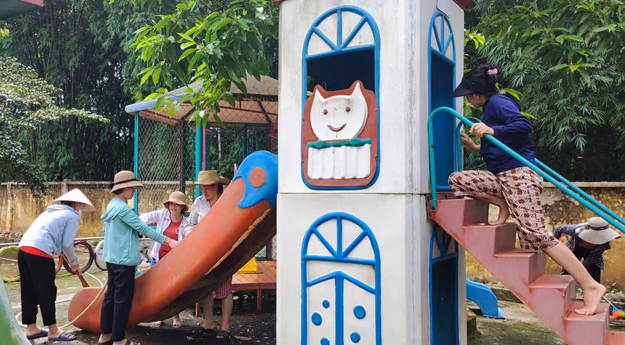 Các cô giáo làm vệ sinh cầu trượt cho trẻ. Ảnh: TL.