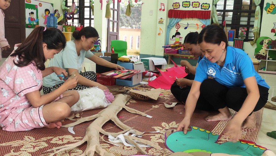 Giáo viên Trường Mầm non Sơn Điện (Quan Sơn, Thanh Hóa) làm đồ dùng, đồ chơi cho trẻ. Ảnh: TL.