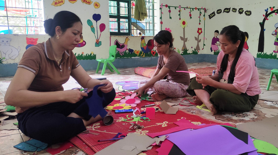 Cô Nguyễn Thị Nhung, Hiệu trưởng Trường Mầm non Sơn Điện (ảnh trái) cùng giáo viên làm đồ chơi cho trẻ.