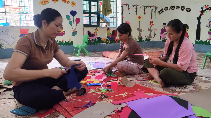 Cô Nguyễn Thị Nhung, Hiệu trưởng Trường Mầm non Sơn Điện (ảnh trái) cùng giáo viên làm đồ chơi cho trẻ.