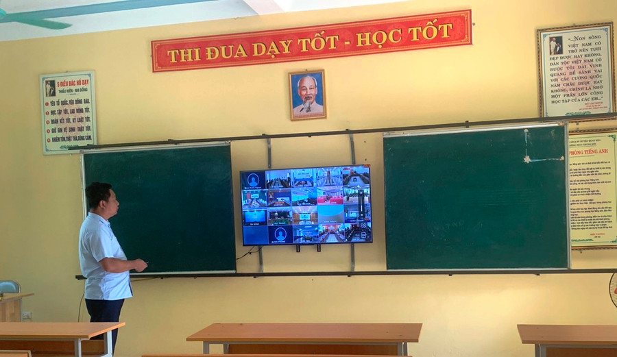 Thầy giáo Trương Đức Văn, Hiệu trưởng Trường THCS Trung Sơn (Quan Hóa, Thanh Hóa) kiểm tra đường truyền qua SmartTV để chuẩn bị sự kiện vào sáng mai. Ảnh: Nhà trường cung cấp.