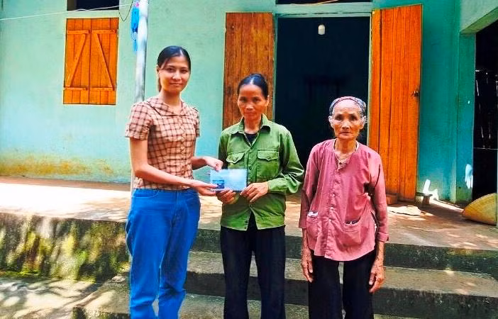 Đại diện Báo GD&TĐ trao tiền do bạn đọc hỗ trợ đến bà Nguyễn Thị Long (mẹ của em Nguyễn Thị Thúy).