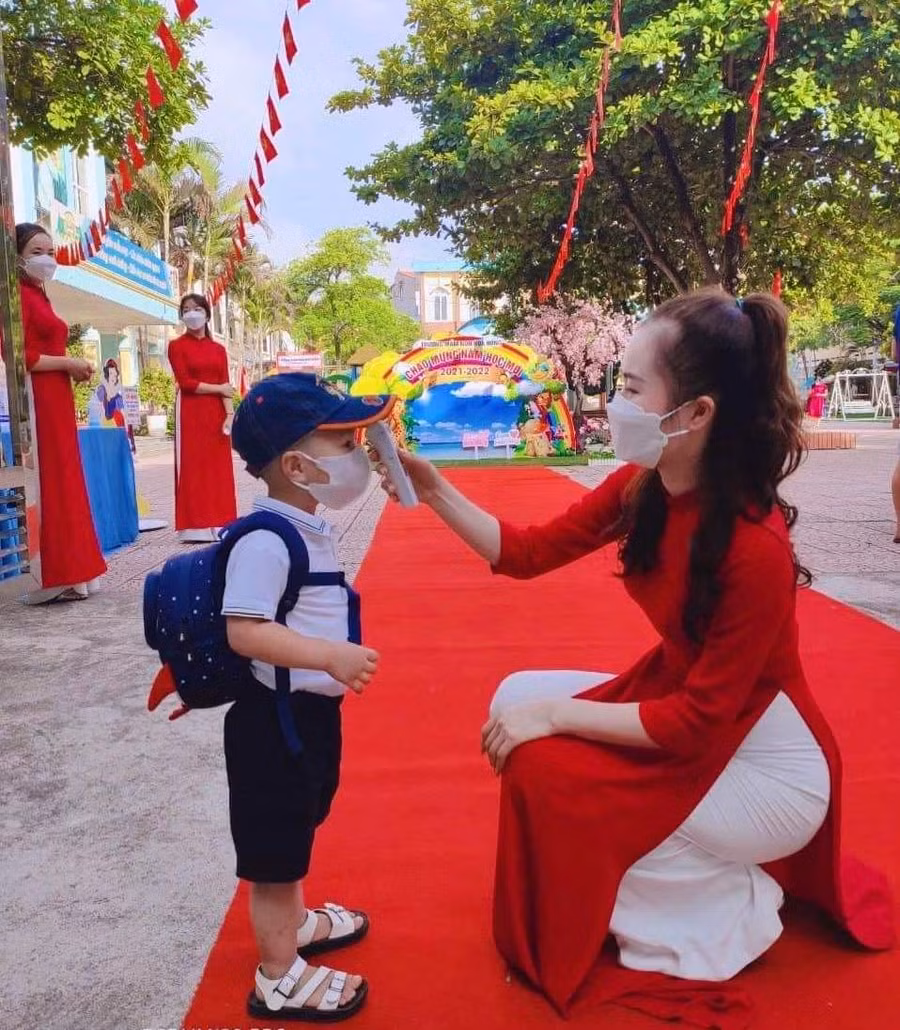 Trẻ được đo thân nhiệt trước khi vào lớp tại Trường MN Hoa Hồng. Ảnh tư liệu