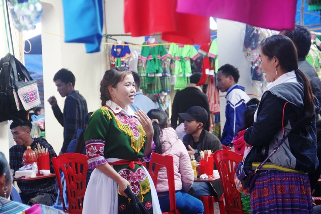 Thiếu nữ dân tộc Mông trao đổi hàng hóa trong chợ.