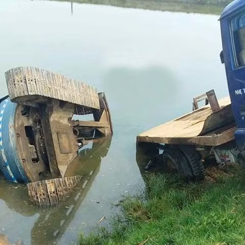 Cả xe tải lẫn máy xúc bánh xích tụt xuống ao Cả xe tải lẫn máy xúc bánh xích tụt xuống ao